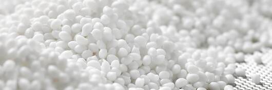 Closeup of a granule of white plastic polymer.